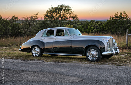 Fotografie, Obraz Classic luxury car on rural road at sunset