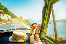 Summer Road Trip With Young Female Legs On Dashboard Inside Of Classic Oldtimer Van Cruising Alongside Sea Coast