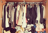 Fototapeta Paryż - Pile of messy clothes in closet. Untidy cluttered woman wardrobe in vintage style.