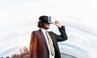 Handsome elegant businessman experiencing impressive virtual reality and business city at backdrop