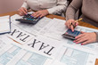 © RomanR - Female hands with calculator and 1040 form