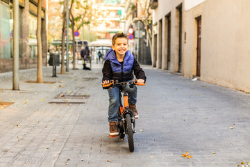 Wall Mural - Little kid riding his bicycle on city street