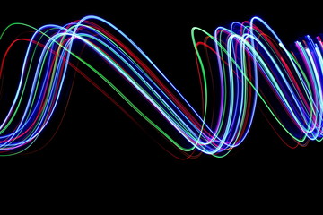 Multi color light painting photography, electric blue, red and green, ripples and waves of vibrant color in parallel lines against a black background