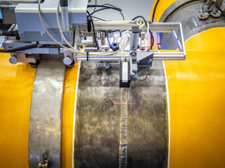Poster - Industrial equipment. Welding pipes. The robot welds the pipe. Gas pipeline Automatic welding. Oil transfer. Yellow pipe.