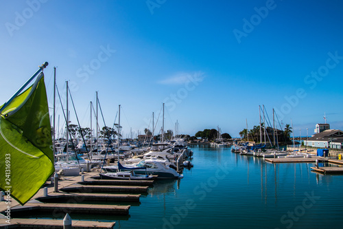 Fotografie, Obraz Small marina with beep blue water and many sail and power boats docked in slips