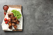 Delicious barbecued meat served on gray table. Space for text