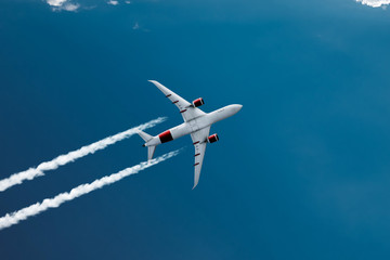 Wall Mural - The plane against the blue sky and fluffy clouds. Concept of vacation, vacation, flight, travel.