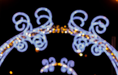 Beautiful Christmas Defocusing Arch illuminated by LED lights in a public park at night.