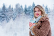 © Masson - Beautiful girl in coat with cup of hot drink in a snow forest. Christmas of Valentine Day season time