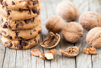 Chocolate chip cookies with walnuts on wooden background