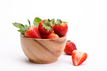 Poster - Red berry strawberry in a wooden bowl isolated on white background. Strawberries with leaves in a wooden bowl. Isolated