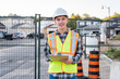 © Brian - Happy young construction worker wearing safety gear and holding a clipboard.