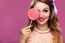 Beautiful Young Woman Holds In Hand Candy. Copyspace On Pink Background