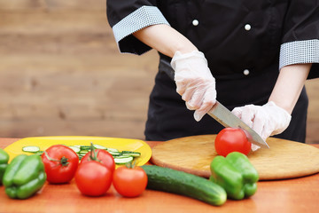 The cook cuts fresh farm vegetables