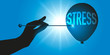 Concept pour supprimer le stress, avec une main qui tient une aiguille pour faire éclater un ballon symbolisant le stress.