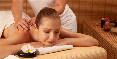 Wall Mural - Beautiful young woman having a massage treatment in spa salon - wellness