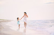 © tutye - Mother and her daughter runing and having fun on the beach