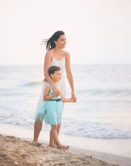 Wall Mural - Mother and her daughter runing and having fun on the beach