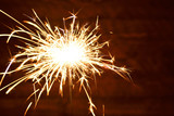 Fototapeta Dmuchawce - Holiday Bengal lights on the dark background. Burning sparkler, Happy New Year.
