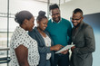 © JonoErasmus - Team of african business people standing and smiling using a tablet