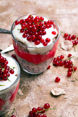 Wall Mural - Healthy dessert with organic red currants, fresh yogurt and corn flakes. Dietary breakfast on a brown background