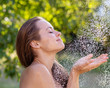 © PhotoGranary - Young woman portrait. Young beautiful and relaxed woman taking shower in garden at sunset.