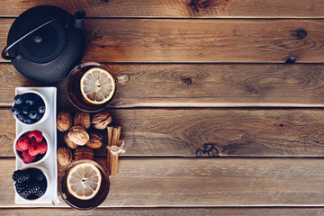 Poster - Flat lay of Cup of te and iron with dried fruit tea, cinnamon and fruits of the forest. vintage style