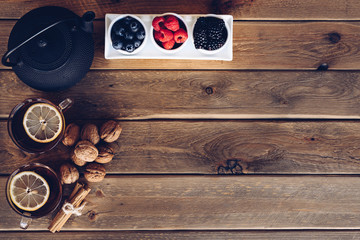 Wall Mural - Flat lay of Cup of te and iron with dried fruit tea, cinnamon and fruits of the forest. vintage style