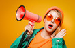 © Masson - Young style girl in jeans clothes with pink megaphone on yellow background. Symbolizes female resistance. Clothes in 1980s style