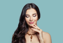 Beauty Fashion Portrait Of Brunette Woman With Makeup, Long Healthy Hair And Amber Necklace And Earrings On Blue Background