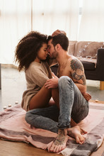 Multiethnic Couple Hugging On Floor At Home