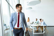 © BGStock72 - Young businessman leaves a meeting while other people stay in office