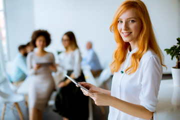 Wall Mural - Pretty young red hair woman using digital tablet