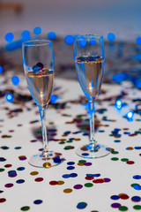 Minimalistic festive background with champagne in glasses and confetti