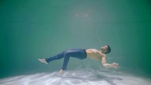 Sexy Half-naked Guy In Jeans Floating Underwater.