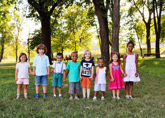 A large group of preschool children playing in the Park on the grass. The concept of friendship, childhood.Children's day, June 1