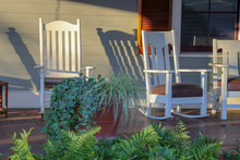 White Rocking Chairs On A Front Porch In Afternoon Or Morning Sun