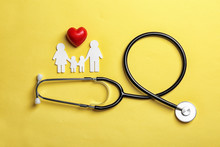 Flat Lay Composition With Heart, Stethoscope And Paper Silhouette Of Family On Color Background. Life Insurance Concept