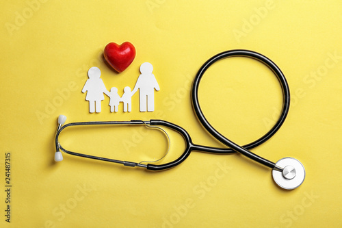 Fotomural Flat lay composition with heart, stethoscope and paper silhouette of family on color background