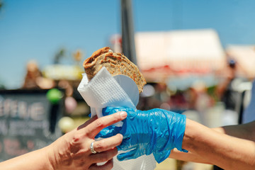 Woman's hand receiving a crepe at a food fair