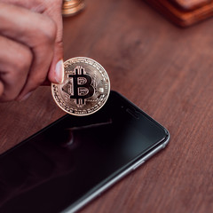 Poster - Cryptocurrency Bitcoin. Hand put coin to smartphone. saving and exchange digital money concept.