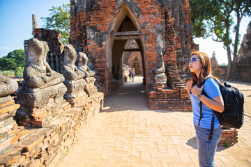 Tourists are shooting portrait. Female photographer photographed in the archaeological site. Selfie portrait. Travel and tourism. Young Asian woman walk at temple in old city of Ayutthaya in Thailand.