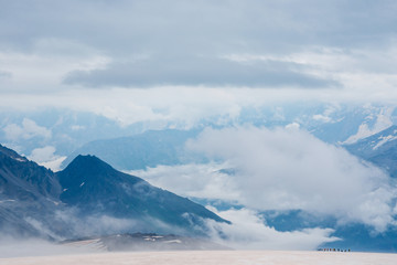 Group of brave tourists on the glacier in Caucasus mountains. Minimalistic