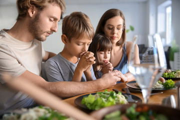 Wall Mural - Family praying before meal at home