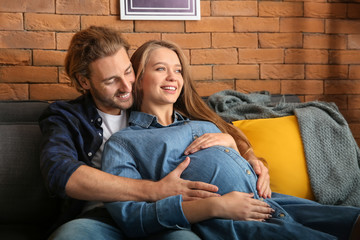 Wall Mural - Young pregnant woman with her husband at home