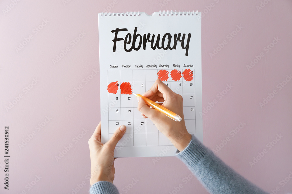 Woman with menstrual calendar on color background