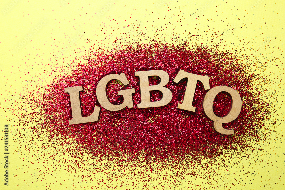 Abbreviation LGBTQ with glitters on color background