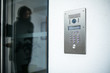 Woman silhouette preparing to enter modern luxury home with focus on the door digital interphone