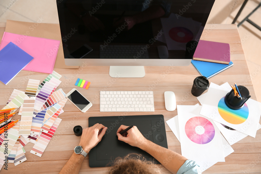 Young designer working at wooden table