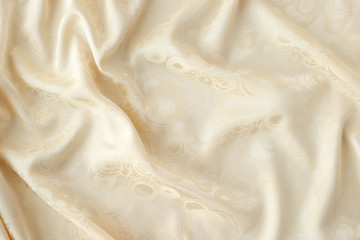Soft fabric background. The folds of the soft beige fabric create a textural background. Fabric for sewing and fashion.